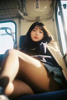 Woman with long black hair and a scarf, sitting indoors with soft lighting
