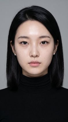 Woman with black hair and a black turtleneck in a studio portrait