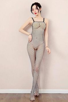 Woman in a black fishnet bodysuit posing indoors