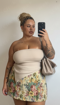 Woman with a braided bun and floral skirt taking a mirror selfie