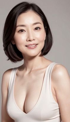 Woman with short black hair wearing a white top with cleavage