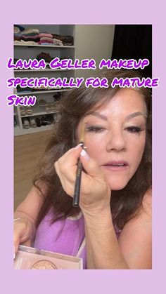 Woman applying eyeliner with a brush, holding a makeup palette