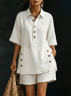 Woman in a white linen shirt and shorts holding a straw bag