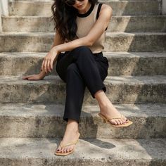 Woman with long hair and sunglasses sitting on concrete steps