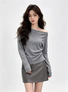 Woman with long dark hair wearing an off-shoulder top and a dark mini skirt