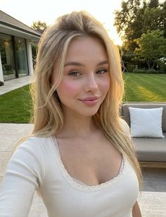 Blonde woman in a white top outdoors during golden hour