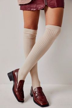 Person wearing a mini skirt, thigh-high socks, and brown loafers