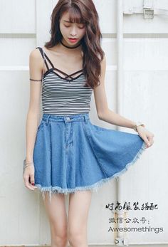 Woman with long hair wearing a striped top and denim skirt outdoors