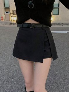 Person in a black skirt and top with an exposed midriff outdoors