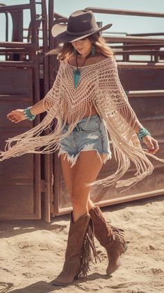 Woman in a cowboy hat, fringe top, and denim shorts outdoors