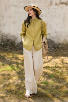 Woman in a straw hat and linen outfit standing outdoors