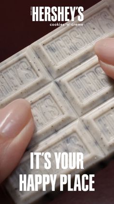 Fingers holding a Hershey's Cookies 'n' Creme chocolate bar