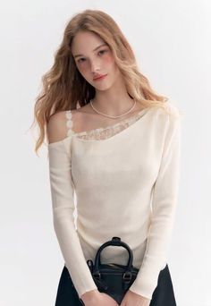Woman with long hair wearing an off-shoulder top and pearl necklace, holding a black handbag