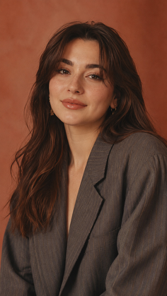 Woman with long brown hair and freckles wearing a pinstripe blazer