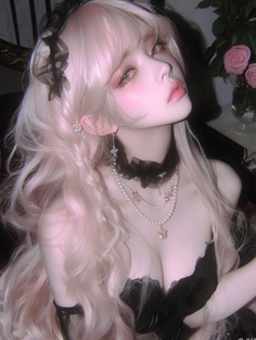 Woman with long blonde hair and a black dress with pearl necklaces