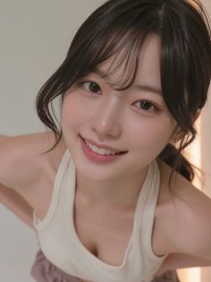 Woman with dark hair and a tank top smiling at the camera