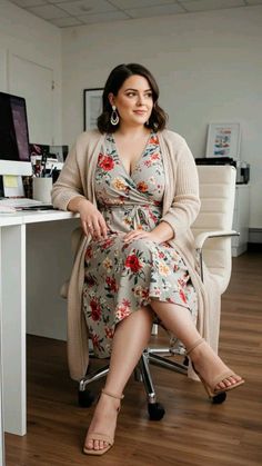 Woman in a floral dress and cardigan sitting in an office chair