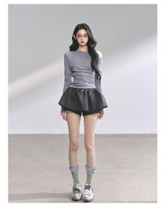 Woman with long hair wearing an off-shoulder top and mini skirt indoors