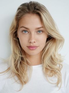 Woman with blonde hair and blue eyes wearing a white t-shirt