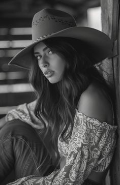 Woman in a cowboy hat and off-shoulder top in black and white