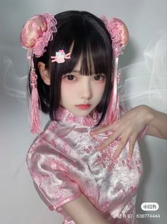 Person in a pink cheongsam with hair buns and pink tassels