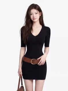 Woman with long hair wearing a black dress and brown belt
