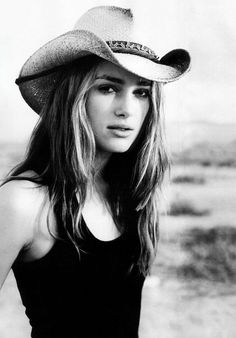Woman in a cowboy hat and black tank top outdoors in black and white
