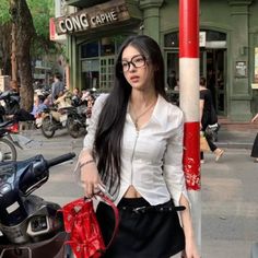Woman with long black hair and glasses on a busy street