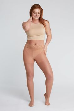 Woman with red hair wearing a crop top and tights with lace trim