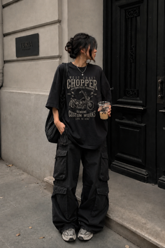 Person in an oversized t-shirt and cargo pants standing on a street
