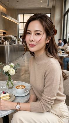 Woman with long hair wearing a turtleneck sweater in a cafe with coffee and cake