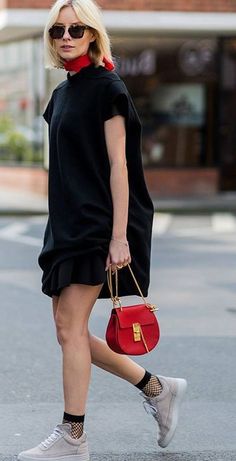 Woman with blonde hair and sunglasses wearing a black dress and red scarf