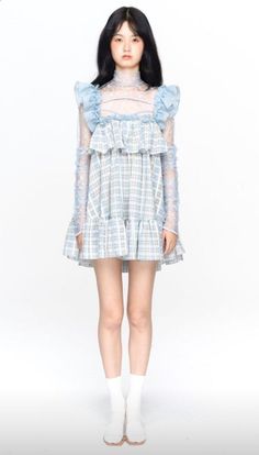 Woman in a blue plaid dress with ruffled sleeves and a lace top