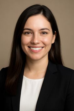 Woman with long dark hair wearing a black suit jacket and white shirt