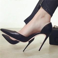 Person wearing black high heels and black jeans with zipper detail