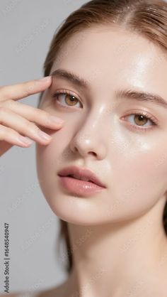 Woman with wet skin and natural makeup, touching her temple