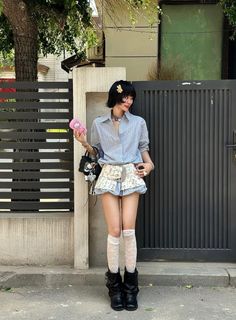 Woman with short hair wearing a striped shirt and floral shorts outdoors