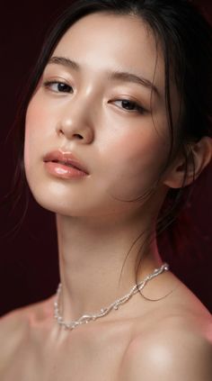 Woman with a delicate necklace and soft lighting on a dark background