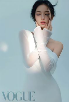 Woman in a white dress with bare shoulders and closed eyes