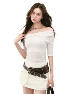 Woman with long hair wearing an off-shoulder top and mini skirt with a wide belt