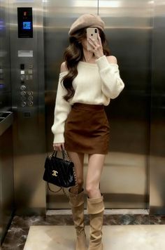 Woman in a beret, off-shoulder sweater, and mini skirt taking a mirror selfie
