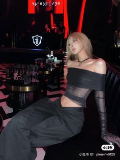 Woman in a sheer off-shoulder top and dark pants in a nightclub