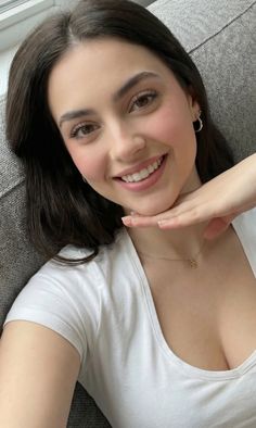 Woman with long dark hair smiling and posing indoors