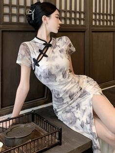 Woman in a patterned cheongsam dress with a high slit and updo hair