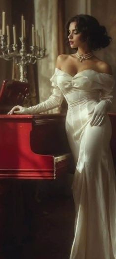 Woman in an off-shoulder dress and long gloves leaning on a red piano
