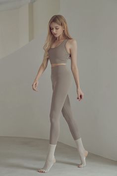 Woman with long blonde hair in a sports bra and leggings with yoga socks