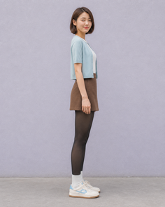 Woman with short hair wearing a cardigan, mini skirt, and tights, standing in side profile