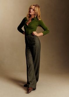 Woman with long blonde hair wearing a green top and plaid pants in a studio
