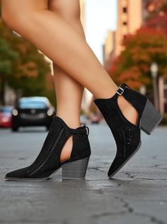 Woman wearing black cutout boots with high heels on a street