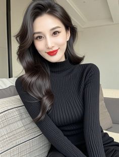 Woman with long dark hair and red lipstick wearing a black turtleneck indoors